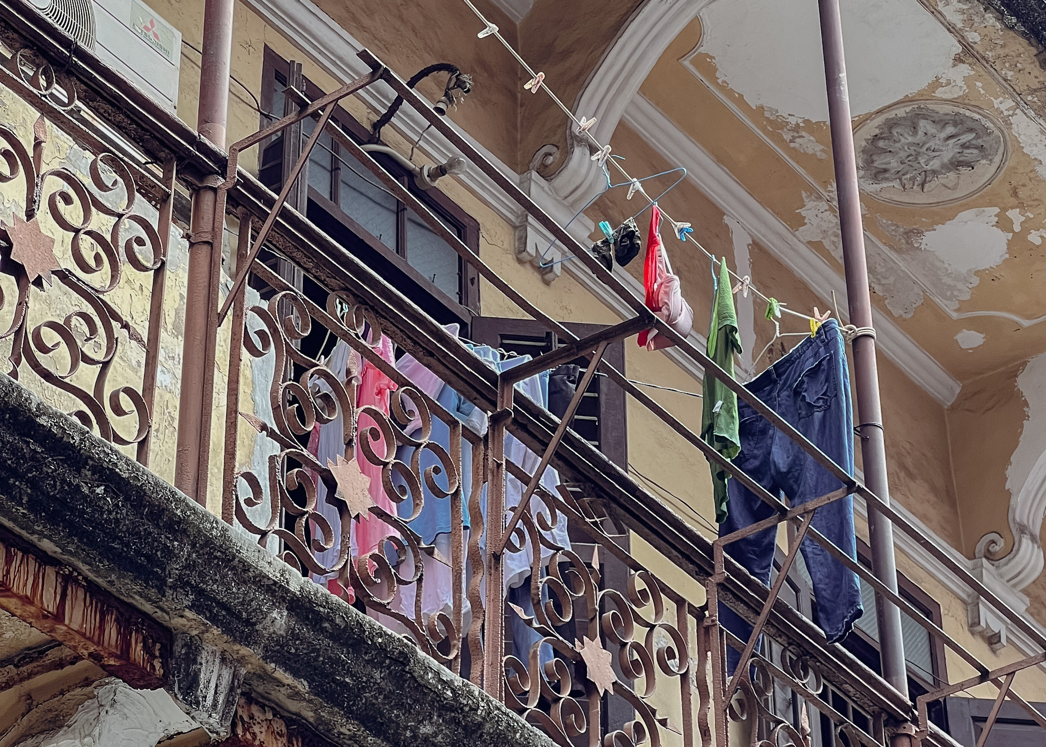 Balcony of a residential building showing railing with heart design and hung clothes